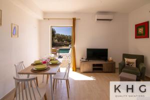 un soggiorno con tavolo da pranzo e TV di Skoumas villa surrounded by Olive trees! a Vlachata
