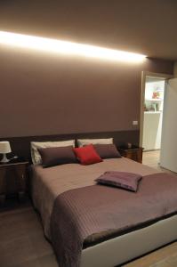 a bedroom with a large bed with red pillows at Le Sartorie in Pozzuolo del Friuli