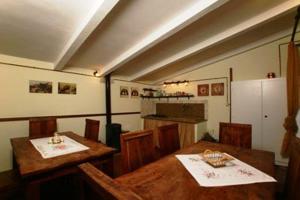 a dining room with two tables and a kitchen at Le Camere Di Paolino in Manciano