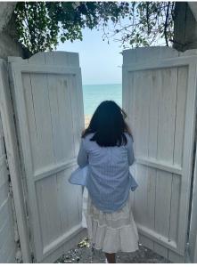 Une jeune fille qui regarde une clôture sur l'océan dans l'établissement Villa Afon, à Nouvel Athos