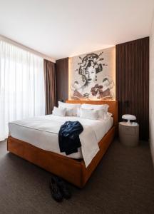 a bedroom with a large bed with a painting on the wall at Duomo Hotel & Apartments in Milan