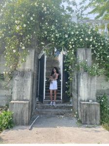 une femme debout à la porte d'une arche avec des fleurs dans l'établissement Villa Afon, à Nouvel Athos