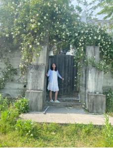 une femme debout à l'entrée d'une porte en bois dans l'établissement Villa Afon, à Nouvel Athos