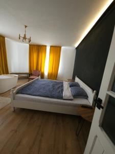 1 dormitorio con cama, bañera y lavamanos en Pensiunea Mango, en Predeluţ