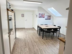 a dining room with a table and black chairs at Geräumige Apartments mit Garten in Dahlem