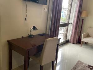 a desk with a lamp and a chair in a room at Geza Apartment Hotel in Addis Ababa