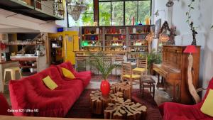 a living room with red couches and a piano at Nid aigle 3 Suites in Rio de Janeiro