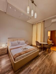 a bedroom with a bed and a table and chairs at Prince of Lake Hotel in Shkodër