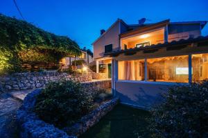 a house with a stone wall next to a building at Villa Lily Comfortable holiday residence in Veli Iž