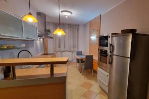 a kitchen with a stainless steel refrigerator and a table at Family apartment in Dolný Kubín