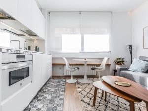 Il comprend une cuisine et un salon avec une table et un canapé. dans l'établissement apartamento reformado en la calle pez, à Madrid