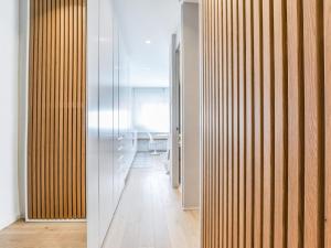 un couloir avec des murs lambrissés et une chambre avec une table dans l'établissement apartamento reformado en la calle pez, à Madrid
