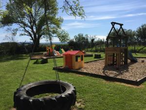 a playground with a tire swing and a play equipment at RB Contractor Stays - Celyn in Pwllheli