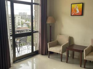 una stanza con tavolo e sedie e una grande finestra di Geza Apartment Hotel ad Addis Abeba