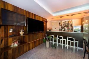 a living room with a television and a bar with stools at Urban Hotel Estacao in Braga