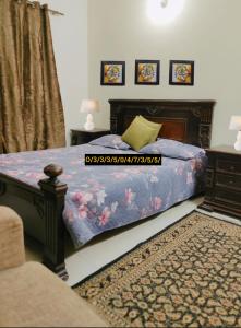 a bedroom with a bed with a blue comforter at 2 bedroom Independent house Valencia town Lahore in Lahore