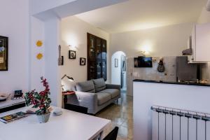 a kitchen and a living room with a couch at Coralie House in Giardini Naxos