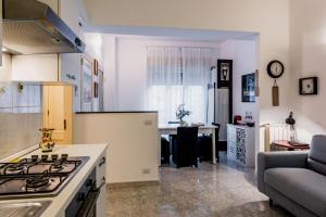 a kitchen with a stove top oven next to a living room at Coralie House in Giardini Naxos