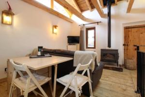 Habitación con mesa, sillas y chimenea. en Charmante maison de hameau traditionnel montagnard en Saint-Marcel
