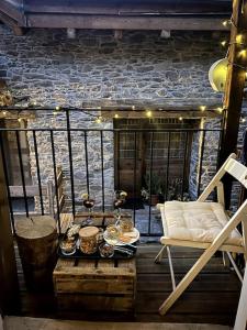 un porche con una silla y una mesa con comida en Charmante maison de hameau traditionnel montagnard en Saint-Marcel