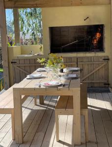 una mesa de picnic de madera con chimenea en la cocina en Hacienda WF - Casa 1, en José Ignacio