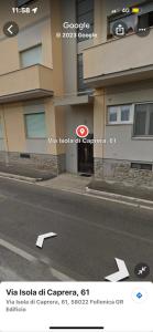 una foto de un edificio con un cartel de flecha en la calle en Casa Caterina- Pratoranieri Follonica, en Follonica