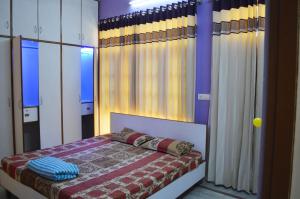 a bedroom with a bed and some curtains at LAVISH Fully Furnished HOMESTAY - ISH, Atithya with various free amenities in Lucknow, INDIA in Lucknow