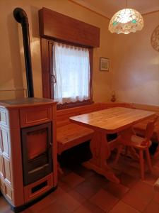 uma cozinha com uma mesa de madeira e um fogão em La tua piccola casa a Pecol em Mareson