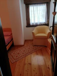 uma sala de estar com uma cadeira e uma janela em La tua piccola casa a Pecol em Mareson