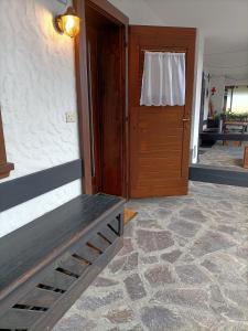 uma porta para um quarto com um banco à frente em La tua piccola casa a Pecol em Mareson