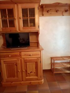 um armário de madeira com uma televisão por cima em La tua piccola casa a Pecol em Mareson