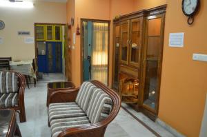 een woonkamer met stoelen en een klok aan de muur bij LAVISH Fully Furnished HOMESTAY - ISH, Atithya with various free amenities in Lucknow, INDIA in Lucknow