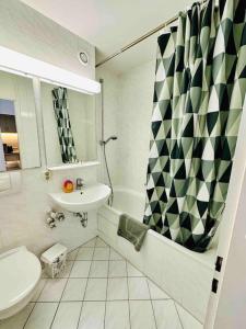 a bathroom with a sink and a toilet and a shower at Schwabing-Studio great sunset view & balcony in Munich