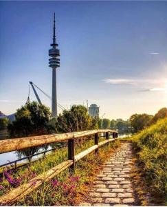 a stone path next to a bridge with a tower at Schwabing-Studio great sunset view & balcony in Munich