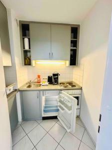 a small kitchen with a sink and a refrigerator at Schwabing-Studio great sunset view & balcony in Munich