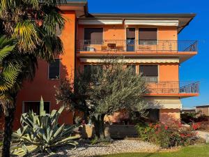 een oranje gebouw met een balkon en een aantal bomen bij Ornella's apartment - Relax near Venice 
