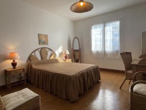 ein Schlafzimmer mit einem großen Bett und einem Fenster in der Unterkunft Mendiko-lorea in Saint-Pée-sur-Nivelle