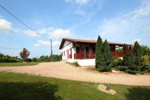 ein kleines Haus mit einem roten Zaun und zwei Bäumen in der Unterkunft Mendiko-lorea in Saint-Pée-sur-Nivelle + 14 Fotos