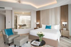 a bedroom with a bed and a chair and a table at Panorama Beachfront Nha Trang in Nha Trang