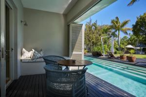 a patio with a table and a swimming pool at The Robertson Small Hotel and Spa by The Living Journey Collection in Robertson