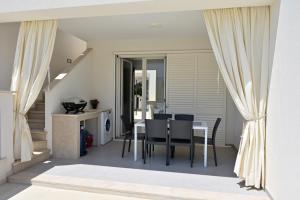 a dining room with a table and chairs at Altamarea Beach Experience Villetta SB in Marina di Pescoluse