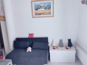 a living room with a blue couch and two cats at Maison a louer dans village de vacances in Pierrefiche
