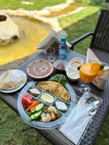 a picnic table with a plate of food on it at Onizah Hotel in Unayzah