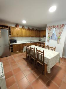 a kitchen with a table and chairs and a refrigerator at Casa Gomez in Gaucín