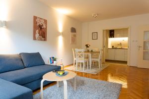 a living room with a blue couch and a table at Apartman Nena in Valjevo