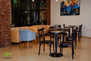 a room with tables and chairs and a couch at Paradise Borjomi Hotel in Borjomi