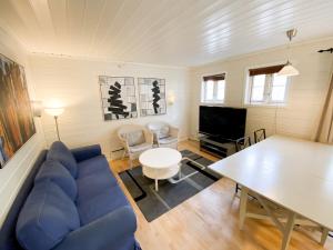 a living room with a blue couch and a table at Tregde Ferie in Mandal