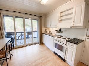 a kitchen with white appliances and a balcony at Tregde Ferie in Mandal