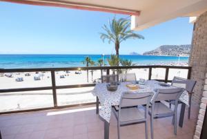 d'une table et de chaises sur un balcon avec vue sur la plage. dans l'établissement Edificio Calpemar, à Calp