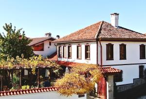 una gran casa blanca con puerta roja en Iliikova House en Kalofer